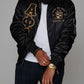Black Alpha Phi Alpha bomber jacket worn with the front zipped