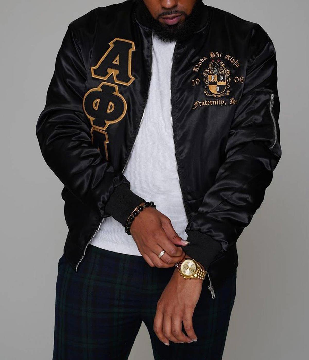 Black Alpha Phi Alpha bomber jacket worn with the front zipped